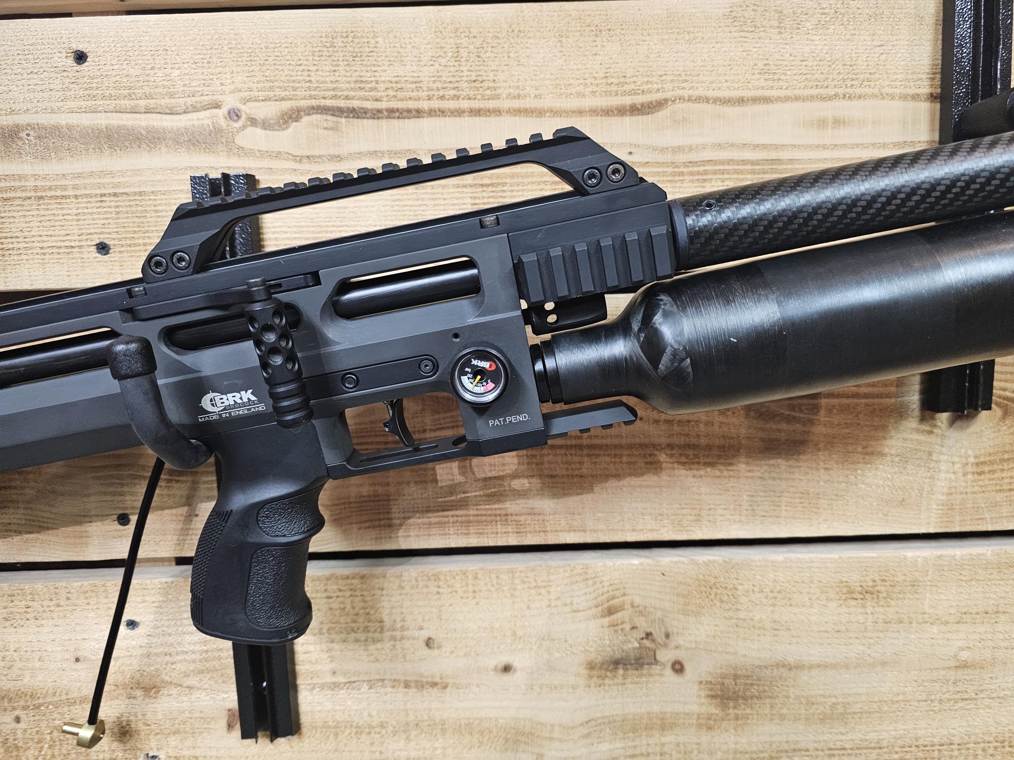 Close-up of a black air gun featuring a carbon fiber barrel and adjustable components.