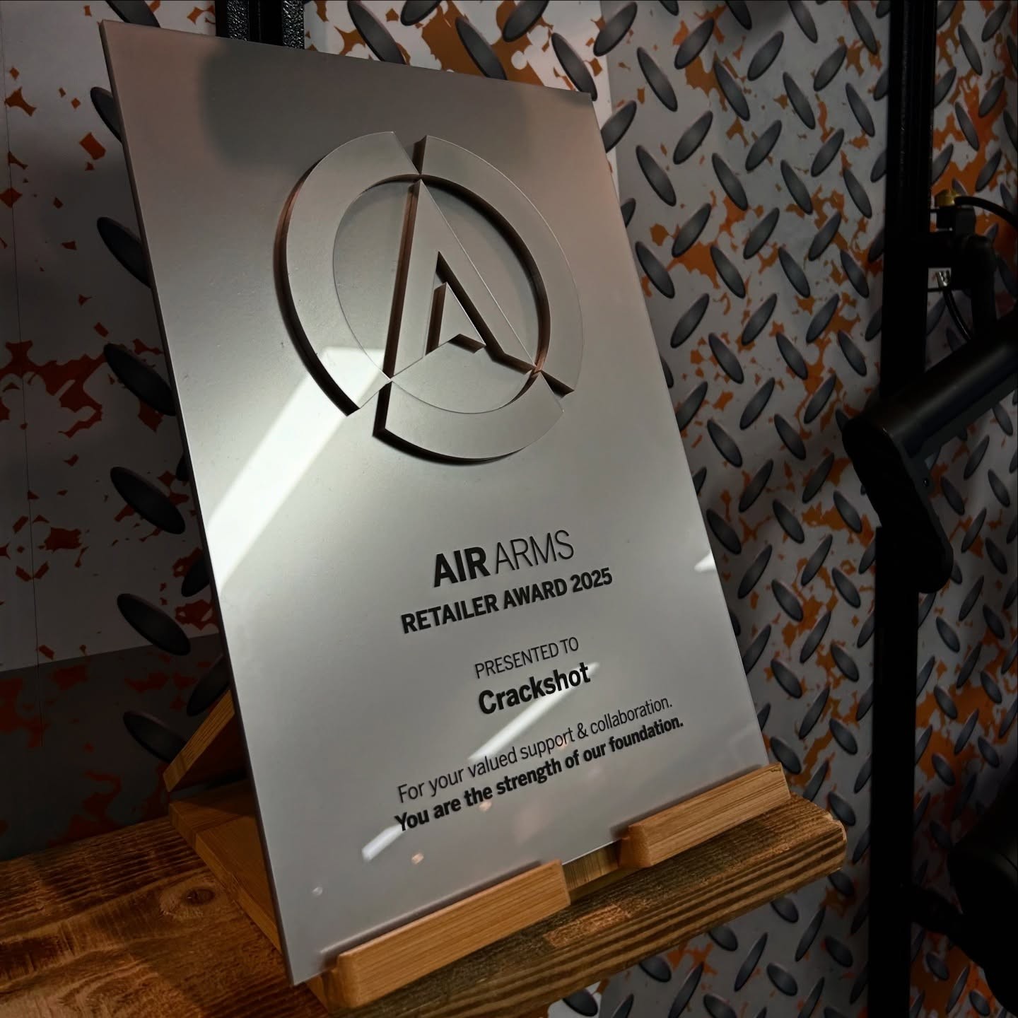 Silver plaque with the Air Arms logo and text recognizing Crackshot as a retailer award recipient for 2025.