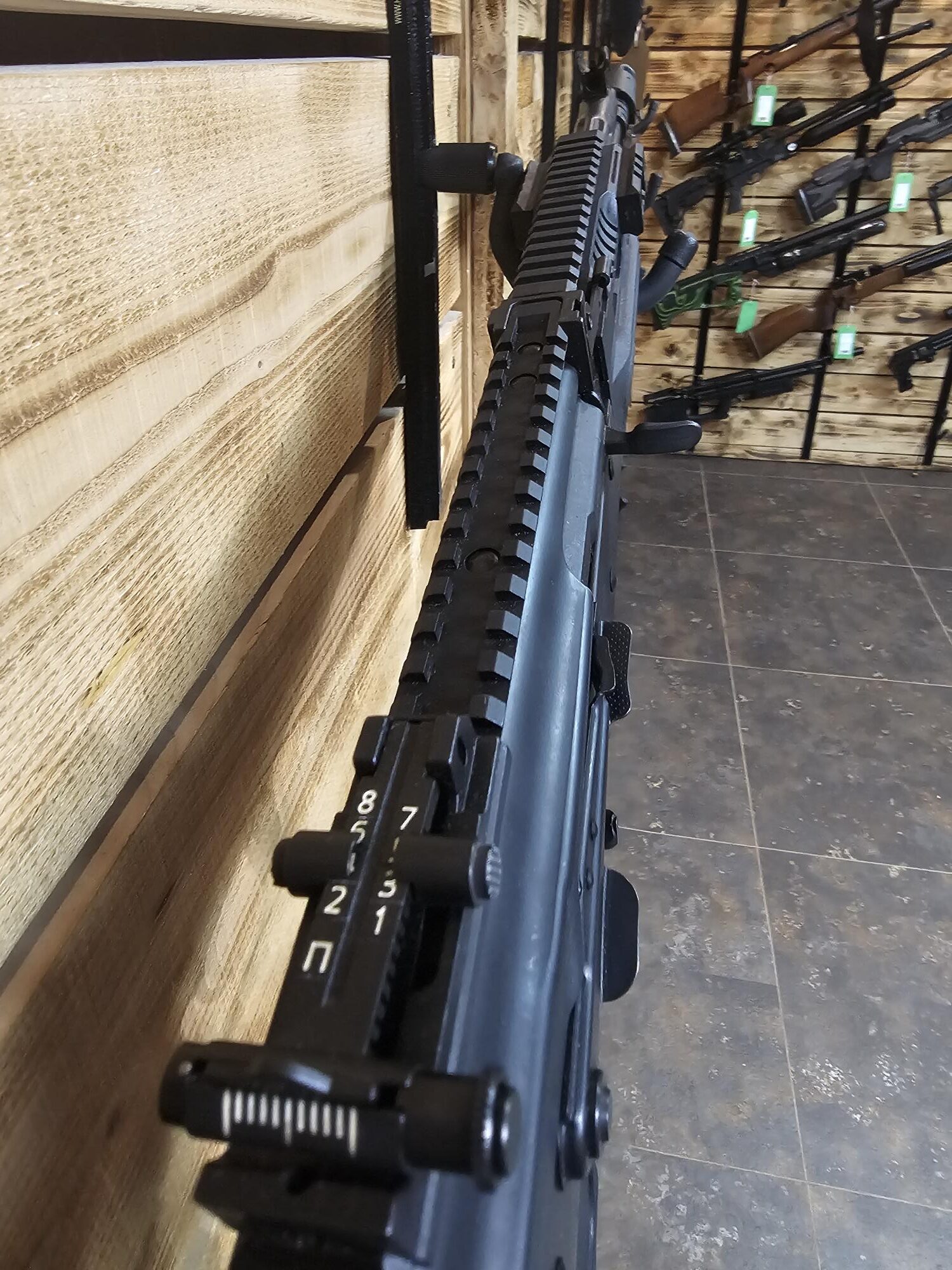 Close view of the Pre-Owned LCT AK airsoft rifle, showing its black receiver, Picatinny rail and adjustable rear sight