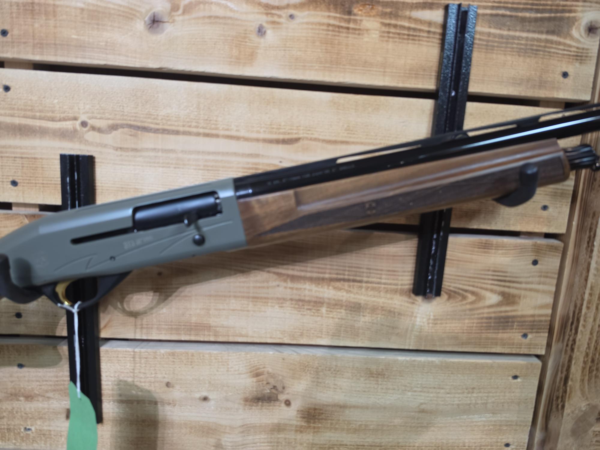 Pre-Owned ATA Semi Auto 12 bore shotgun with a wooden stock and dark receiver displayed on a timber wall