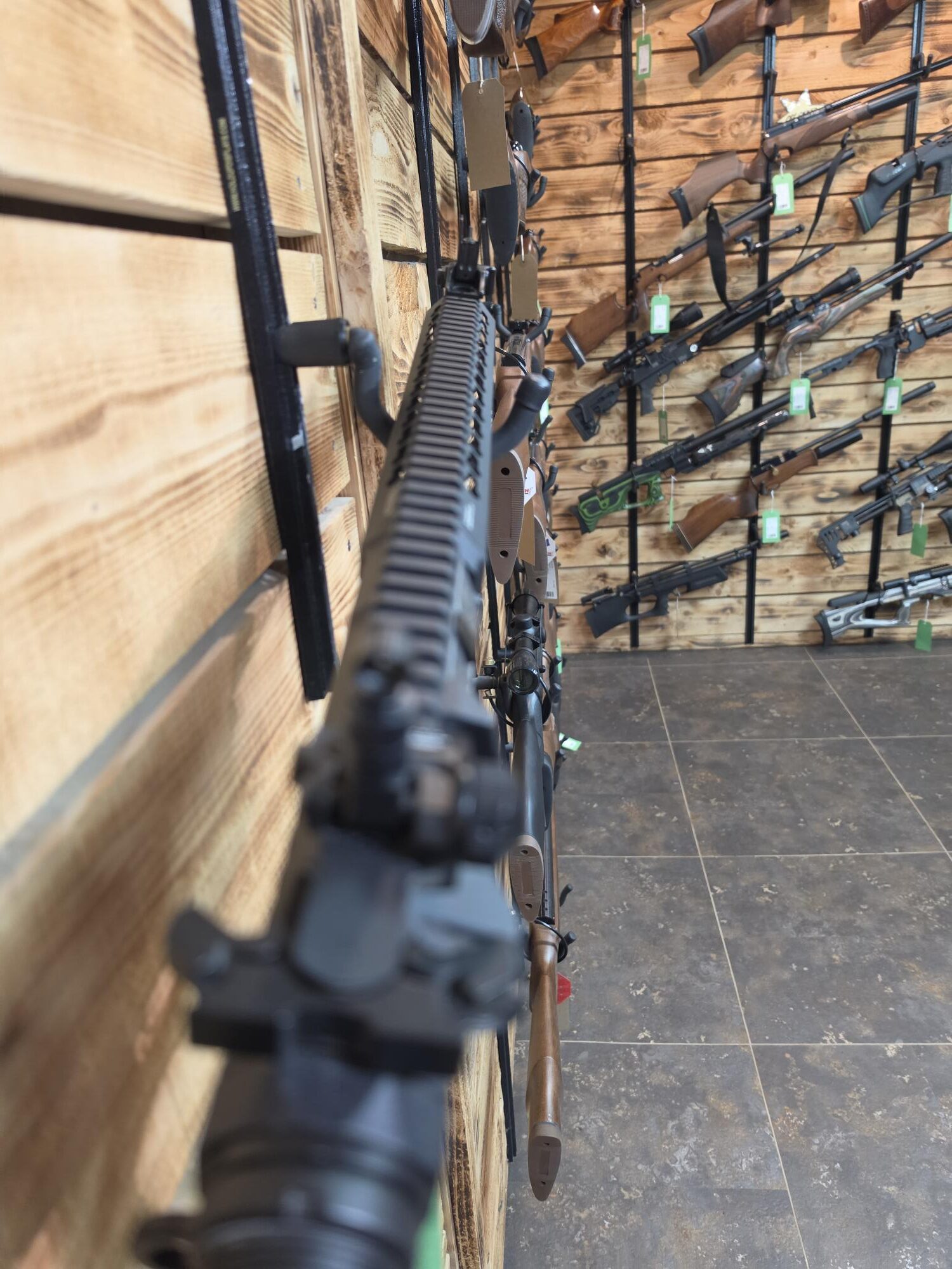 Rifles and air guns line timber display walls at Crackshot, including a pre-owned gun in very good condition.